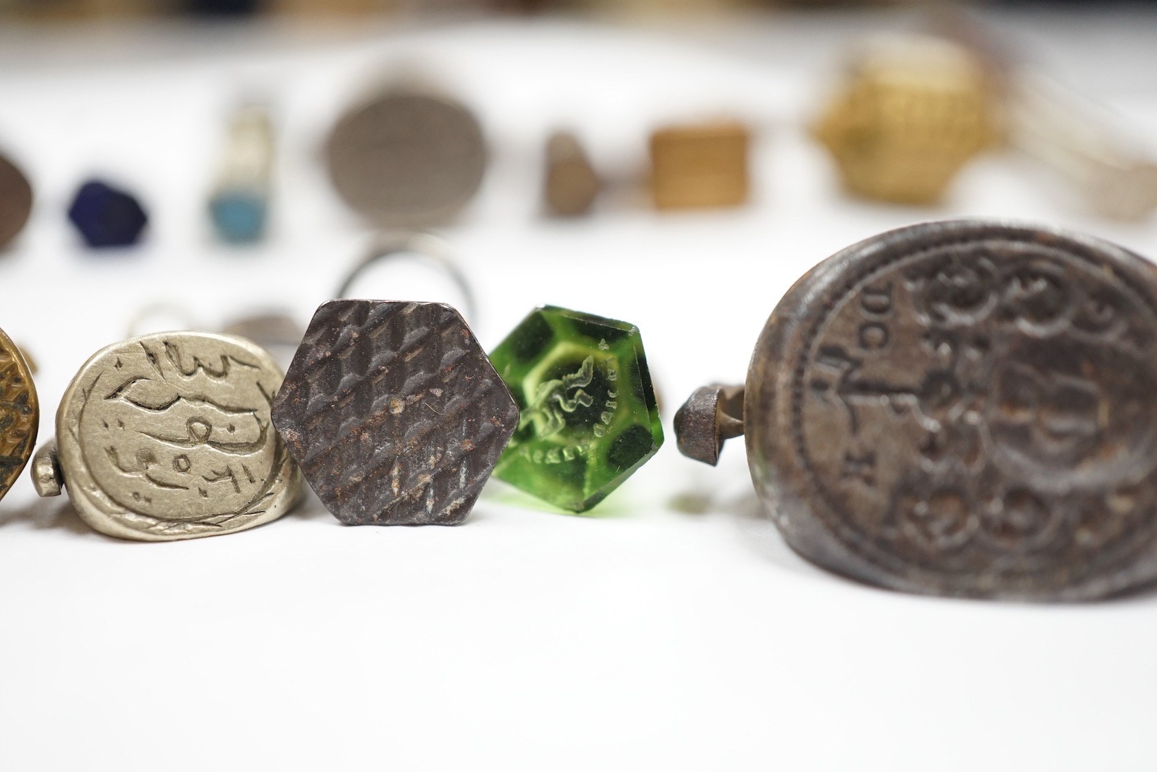 A group of twenty-five steel, gilt metal or nickel fob or desk seals, mostly 19th-century, including a steel swivel seal, a seal with boxwood finial modelled as a hand holding a ball and a nickel multi seal